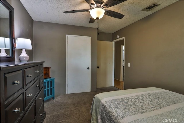 bedroom with ceiling fan, a textured ceiling, and dark colored carpet