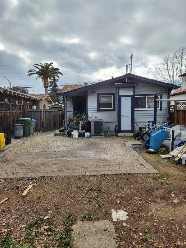 rear view of house with central AC unit and a patio area