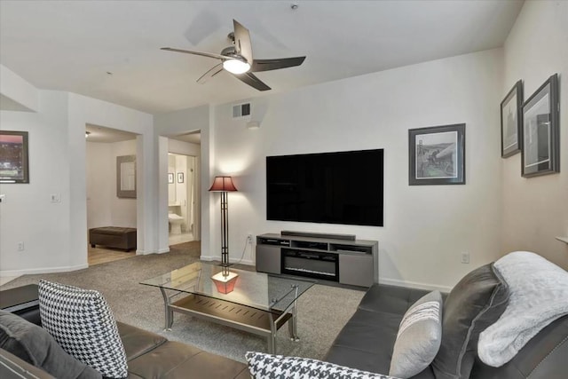 carpeted living room with ceiling fan