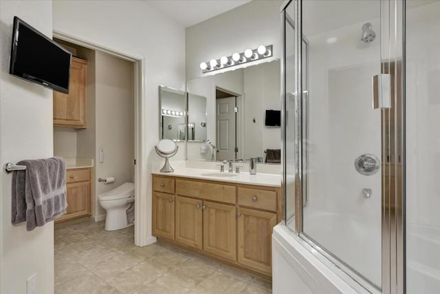 bathroom featuring walk in shower, vanity, toilet, and tile patterned flooring