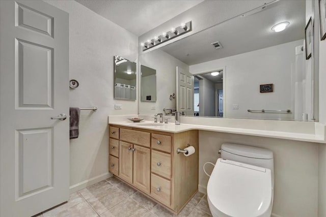 bathroom featuring vanity, tile patterned floors, and toilet