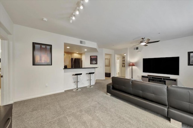 carpeted living room featuring ceiling fan and track lighting