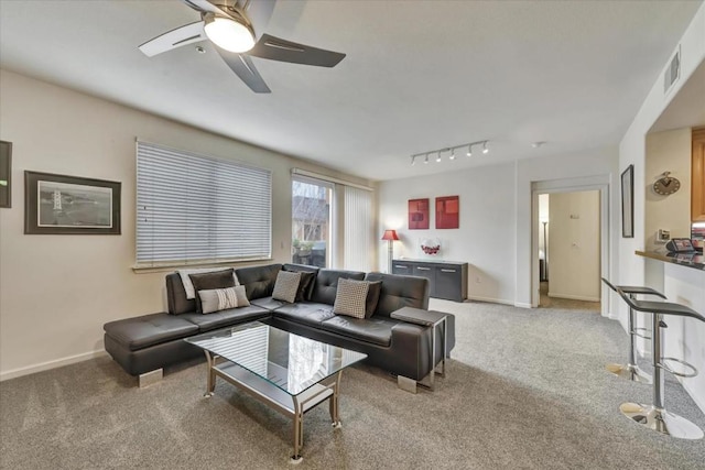 living room with rail lighting, light colored carpet, and ceiling fan