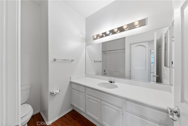 bathroom with vanity, wood-type flooring, and toilet