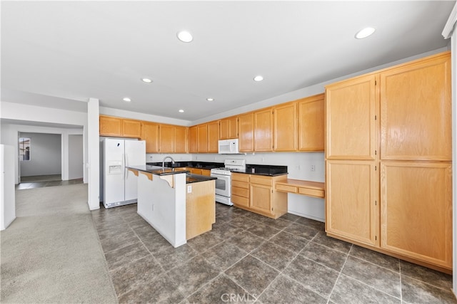 kitchen with sink, white appliances, a kitchen island with sink, built in desk, and a kitchen bar