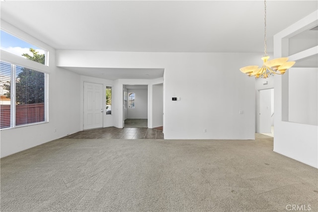 empty room featuring an inviting chandelier and dark carpet