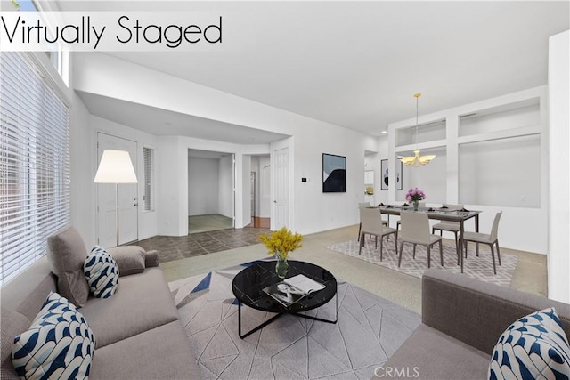 carpeted living room with an inviting chandelier