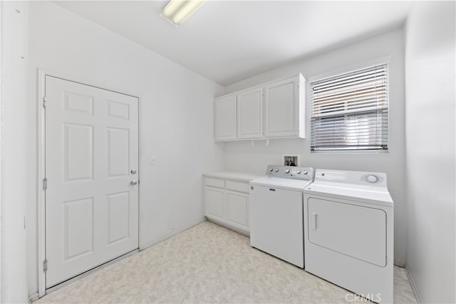 washroom featuring cabinets and washer and clothes dryer