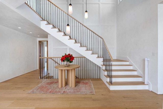 staircase with hardwood / wood-style flooring and a towering ceiling