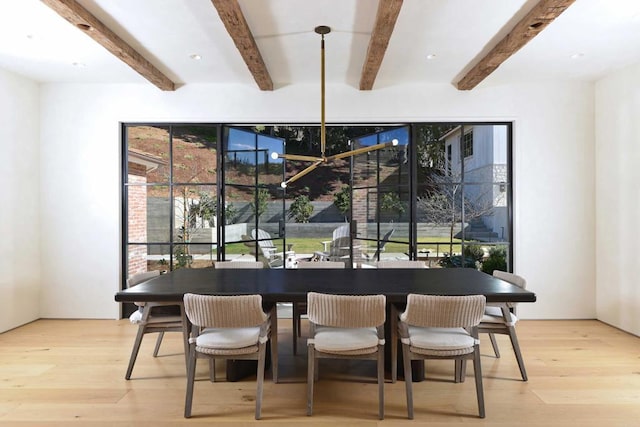 dining area featuring beam ceiling and light hardwood / wood-style floors