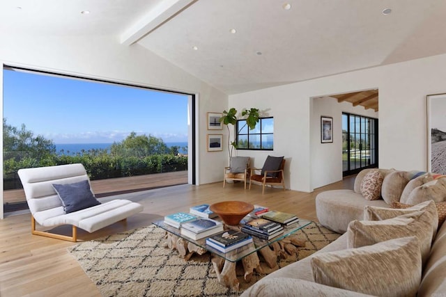 living room with vaulted ceiling with beams and light wood-type flooring