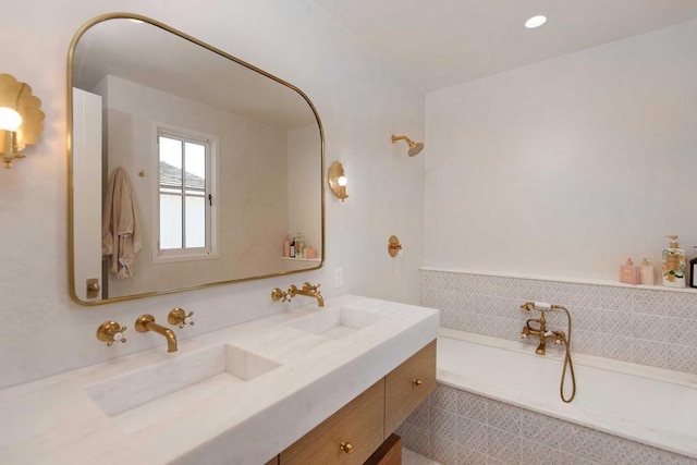 bathroom featuring vanity and tiled bath