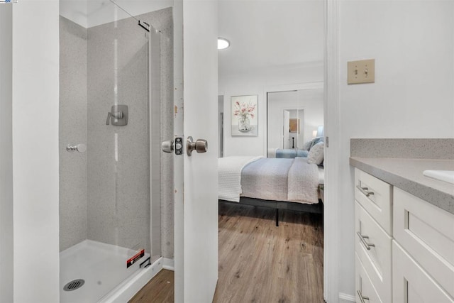 bathroom with wood-type flooring, vanity, and walk in shower