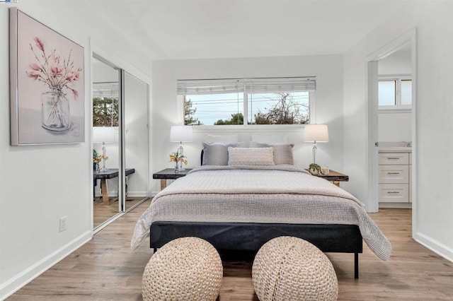 bedroom featuring multiple windows, light hardwood / wood-style floors, and a closet