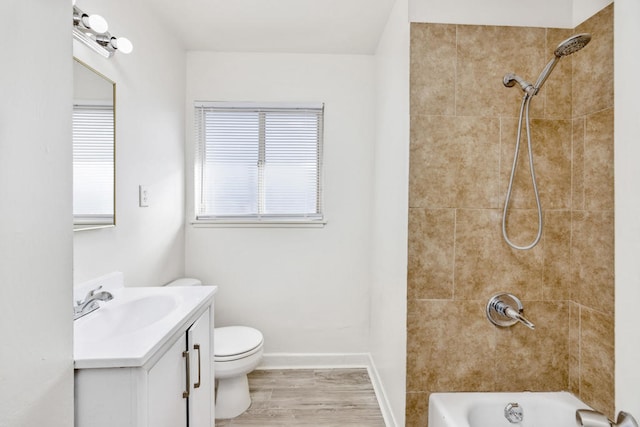 full bathroom with vanity, tiled shower / bath combo, toilet, and hardwood / wood-style flooring