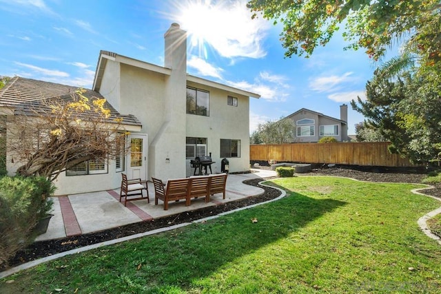 rear view of property with an outdoor living space, a lawn, and a patio