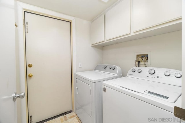 laundry room with washer and dryer and cabinets