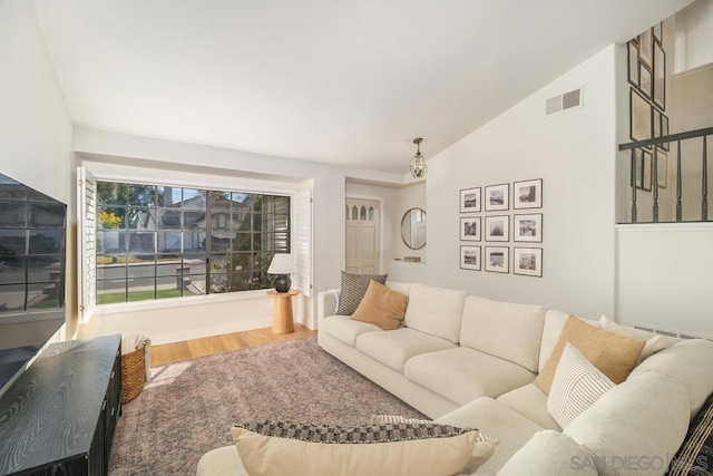 living room featuring hardwood / wood-style floors and vaulted ceiling