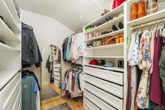 walk in closet featuring vaulted ceiling and light hardwood / wood-style floors