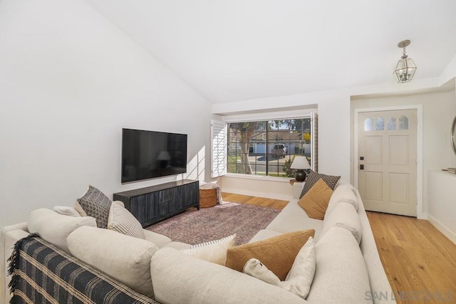 living room with vaulted ceiling and light hardwood / wood-style floors