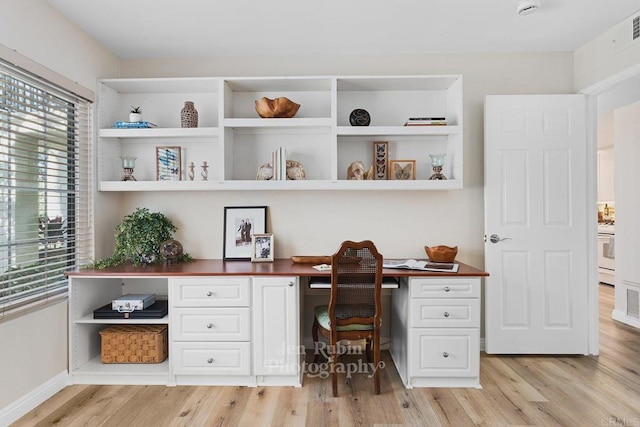 office area with built in desk and light hardwood / wood-style floors