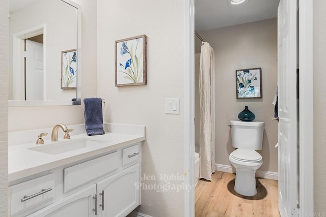 full bathroom featuring vanity, hardwood / wood-style floors, shower / bath combo, and toilet