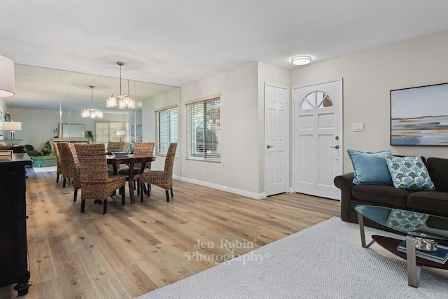 dining space with an inviting chandelier and light hardwood / wood-style floors