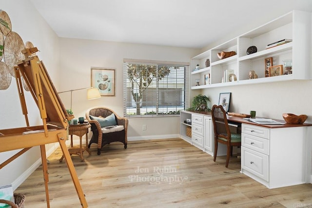 office area with built in desk and light hardwood / wood-style floors