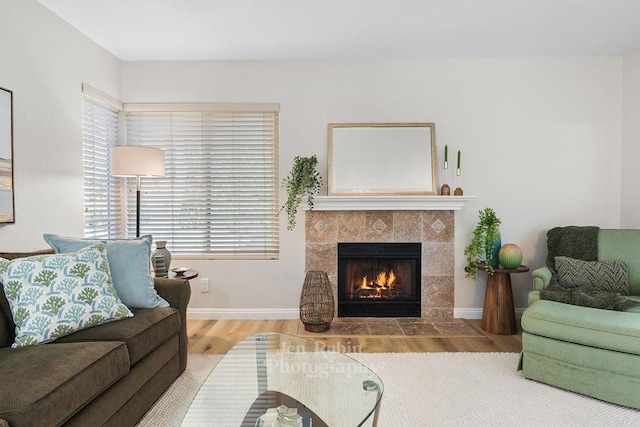 living room with a tiled fireplace and hardwood / wood-style floors