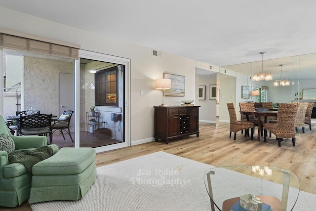 living room featuring a chandelier and light hardwood / wood-style flooring