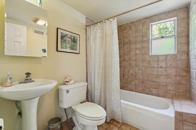 full bathroom with shower / bath combination with curtain, sink, tile patterned floors, and toilet