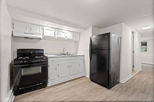 kitchen with sink, white cabinets, light hardwood / wood-style floors, and black appliances