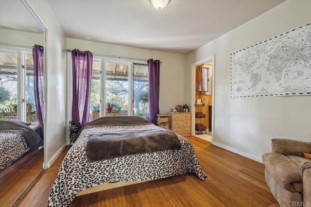 bedroom with connected bathroom and hardwood / wood-style floors