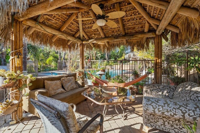 view of patio featuring a fenced in pool, a gazebo, an outdoor living space, and ceiling fan