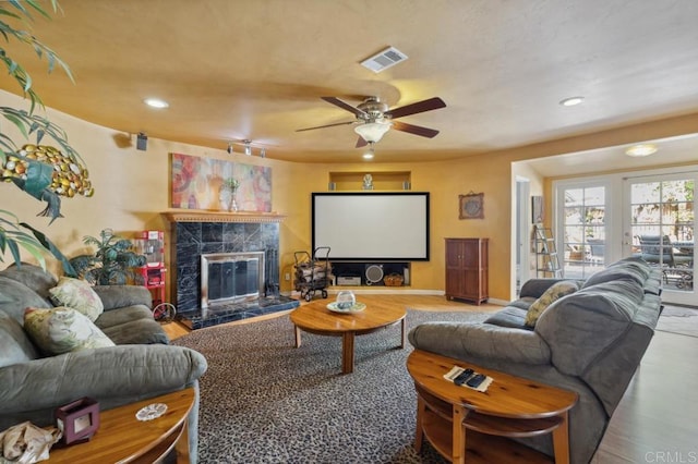 living room with ceiling fan and a fireplace