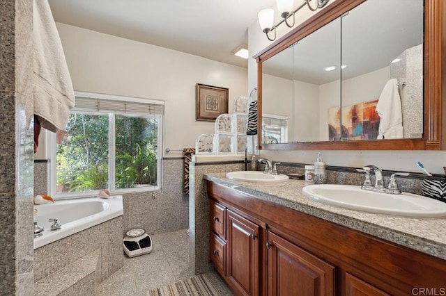 bathroom with tile walls, vanity, and a relaxing tiled tub