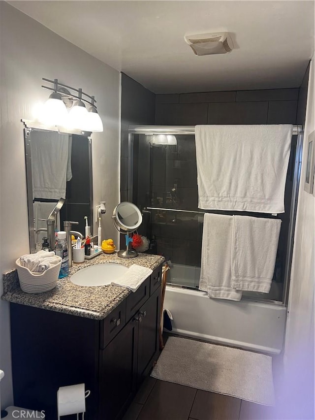 bathroom with vanity and bath / shower combo with glass door