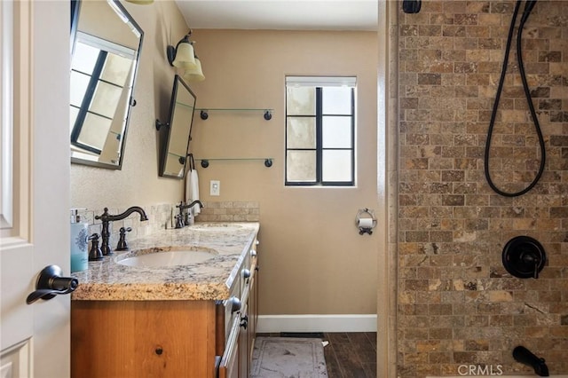 bathroom featuring hardwood / wood-style flooring, vanity, and walk in shower