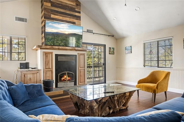 living room featuring a large fireplace, dark hardwood / wood-style floors, and high vaulted ceiling