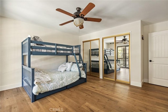 bedroom with multiple closets, ceiling fan, and hardwood / wood-style flooring