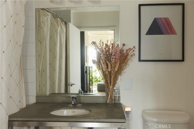 bathroom featuring a shower with curtain, sink, and toilet