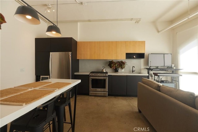 kitchen featuring pendant lighting, a breakfast bar area, appliances with stainless steel finishes, tasteful backsplash, and light brown cabinets