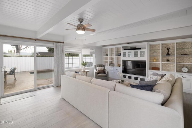 living room with ceiling fan, beam ceiling, and light wood-type flooring