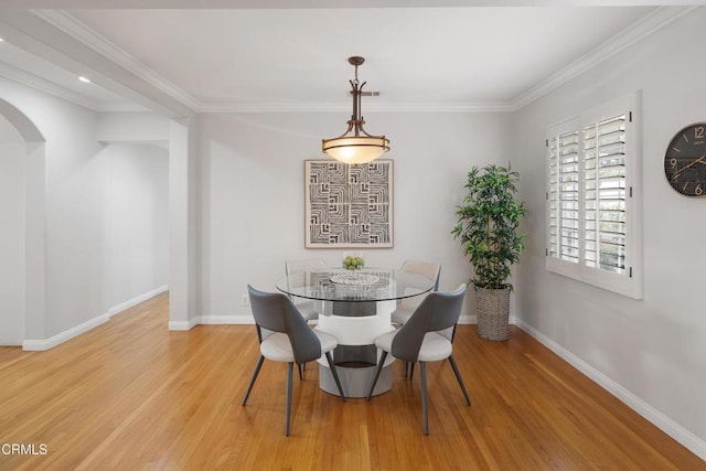 dining area with ornamental molding and light wood-type flooring