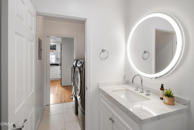 bathroom with tile patterned flooring, vanity, and washing machine and clothes dryer