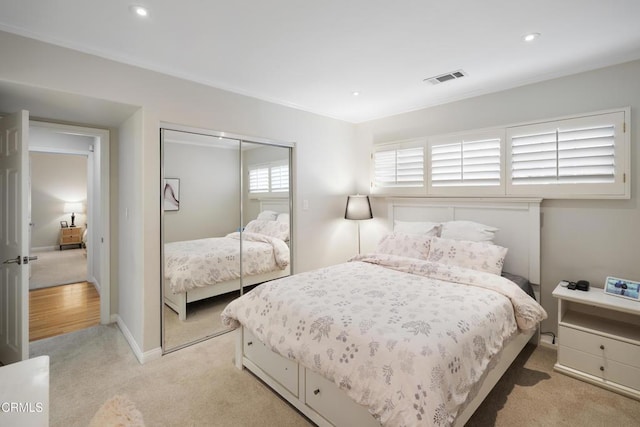 bedroom with light carpet and a closet