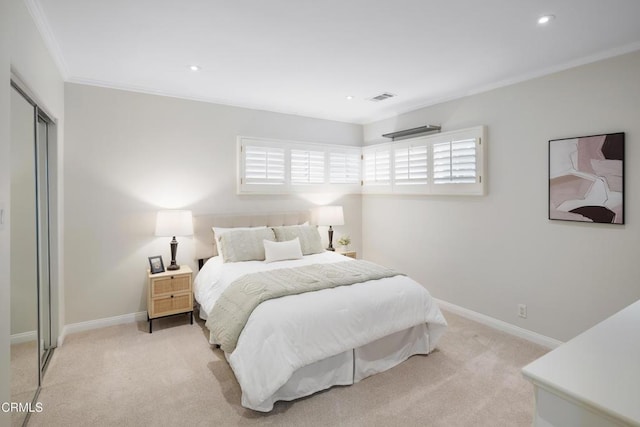 carpeted bedroom with ornamental molding and a closet