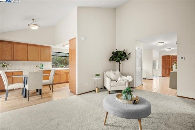 carpeted living room with high vaulted ceiling