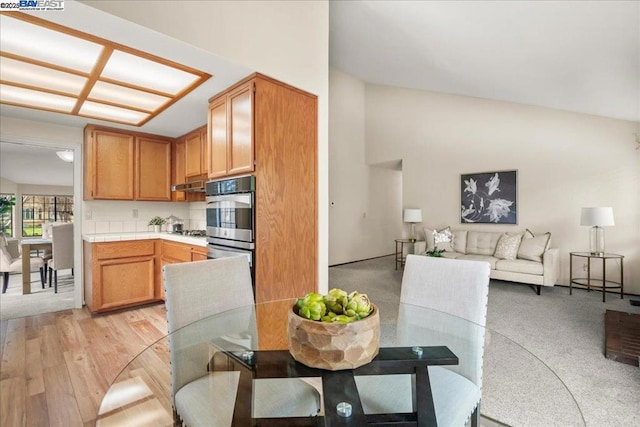 dining space with vaulted ceiling and light hardwood / wood-style floors