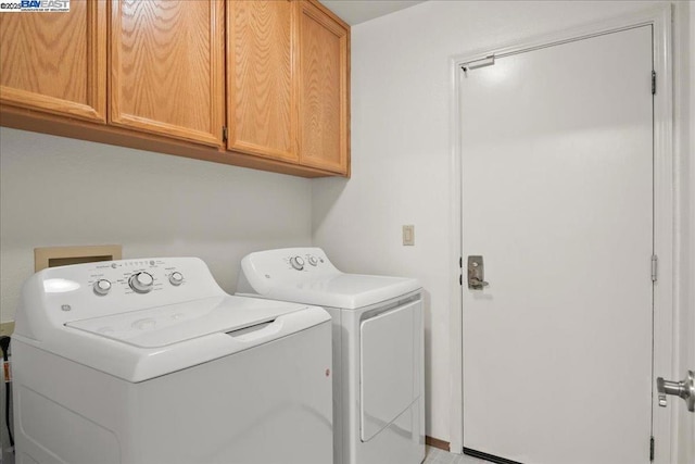 washroom featuring washer and dryer and cabinets